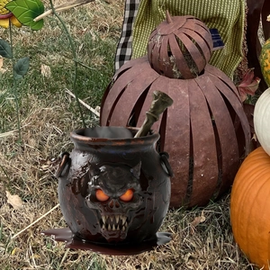 Halloween Hexenkessel Deko mit Totenkopf-Relief und leuchtenden Augen im Garten