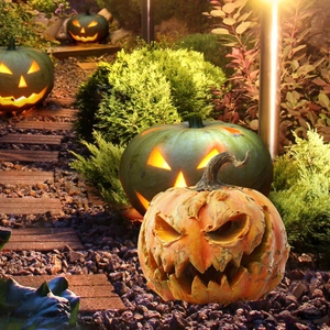 Detailed view of textured Halloween pumpkin stake with glowing lanterns in garden setting