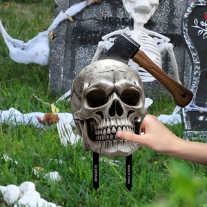 Detailed view of Halloween skull garden stake with axe decoration in themed yard