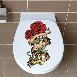 Detalle de la pegatina gótica con rosa roja y mano de esqueleto en la tapa del inodoro