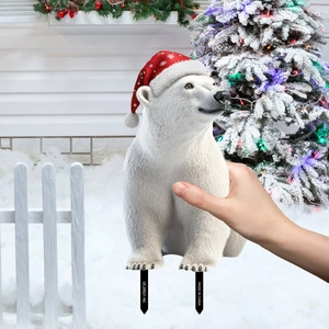Outdoor Christmas polar bear garden stake decoration with festive red hat in snow