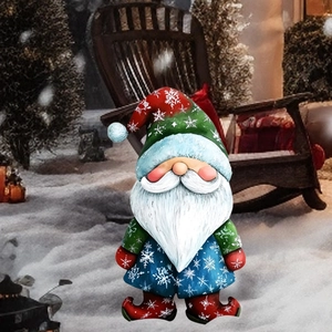 Gros plan d'un nain de jardin de Noël avec un chapeau à flocons dans un décor d'hiver