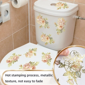 Detail of floral wall stickers with golden edges and pink roses on a toilet lid