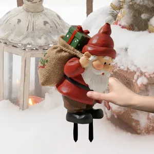 Piquet de jardin nain de Noël avec sac en toile de jute sur fond de neige décorée