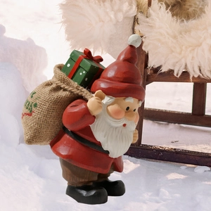 Détail d'un nain de Noël rouge avec boîte cadeau verte et sac Merry pour le jardin
