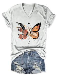 Close-up of white V-neck T-shirt with magic butterfly floral print and blue denim shorts