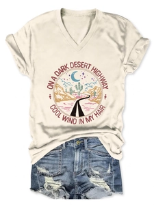 Flat lay of cream V-neck T-shirt with desert highway print and distressed denim shorts