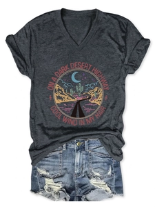 Flat lay of women's V-neck t-shirt with desert print and ripped denim shorts