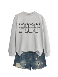 Flat lay of gray PICU sweatshirt paired with distressed blue denim shorts on white background