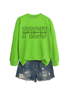 Detailed flat lay of lime green PICU pediatric crewneck sweatshirt with denim shorts