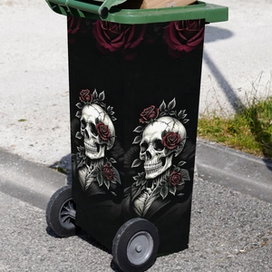 Gothic skull and red rose decal on a green outdoor trash can with a cracked artistic design