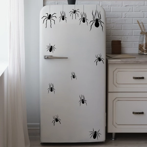 Hand-painted black spider wall stickers set against a white refrigerator for Halloween