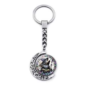 Detail of vintage silver moon keychain with rotating witch and black cat illustration