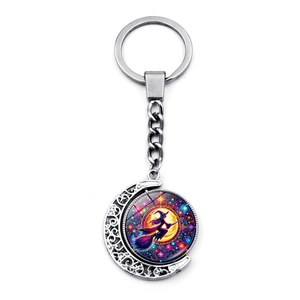 Rotating Halloween witch on broom keychain with silver crescent moon and purple stars