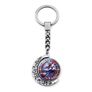 Detail view of double-sided rotating crescent moon witch keychain in silver metal finish