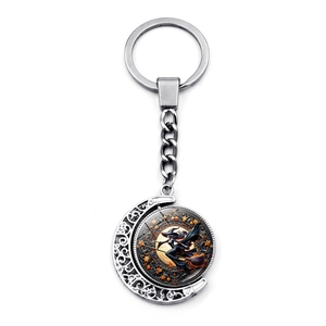 Detail of silver hollow moon keychain with rotating Halloween witch and autumn maple leaves