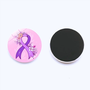 Détail d'un aimant de frigo avec ruban rose, motifs floraux violets et support magnétique souple