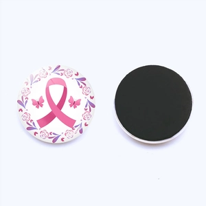 Détail macro de l'aimant de frigo rond avec ruban rose et fleurs pour la sensibilisation