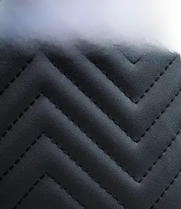 Close-up detail of black leather backpack with premium chevron quilted embroidery pattern