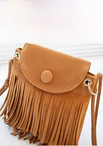 Gros plan sur un sac en daim marron avec de longues franges denses et un anneau doré