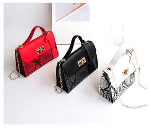 Detailed close-up of snakeskin texture and golden lock on red, black, and white bags