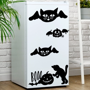 Detail of Halloween winged cat and pumpkin decals on a white refrigerator surface