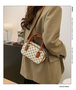Detailed view of retro Boston barrel bag with clover pattern and brown handles