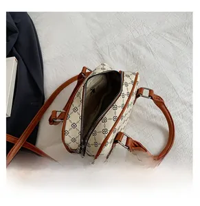 Interior view showing the storage space and zipper pocket of this beige Boston bag