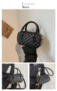 Detail view of black Boston barrel bag with white geometric patterns and silver hardware