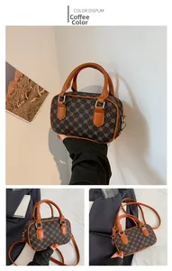 Close-up of brown geometric pattern and smooth leather handle on a Boston bag