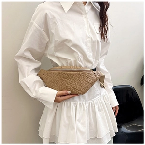 Détail du sac de poitrine tressé kaki sur mannequin en robe chemise blanche