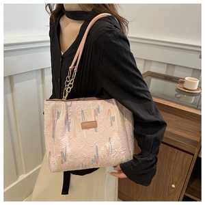 Detalle del bolso tote rosa claro con textura de diamantes y bordado de colores