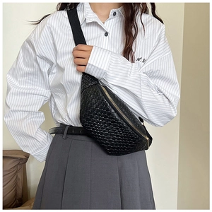 Détail du sac ceinture noir tressé avec fermeture dorée porté sur un mannequin