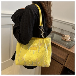 Détail du cabas jaune avec tissu texturé en losanges et broderies colorées élégantes