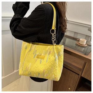 Détail du sac cabas plissé jaune avec broderies colorées et chaîne dorée