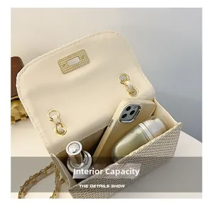 Detail view of woven crossbody bag showing interior capacity with chain strap and gold lock
