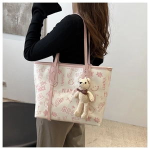 Dettaglio della borsa tote in PU con stampe graffiti rosa e ciondolo a forma di orso