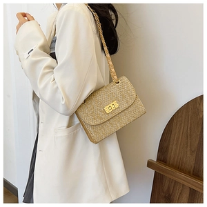 Detail of gold tweed woven bag featuring metallic chain strap and gold clasp closure