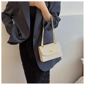 Detail of beige woven square bag with gold chain strap and metal turn-lock closure