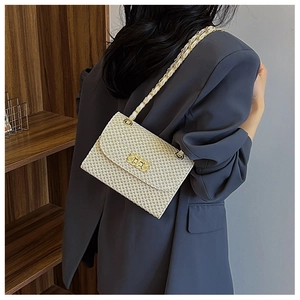 Detail of cream woven crossbody bag showing textured craftsmanship and gold metal buckle