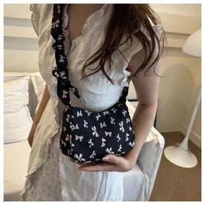 Detail of floral drawstring shoulder bag with ruffled strap and vintage bow patterns