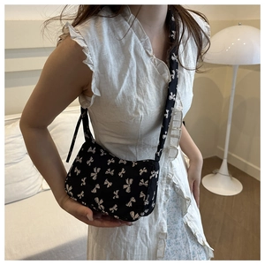 Floral canvas baguette bag with white bow pattern and adjustable drawstring strap