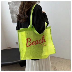 Neon green mesh beach tote bag with red Beach Vibes text shown on model's shoulder