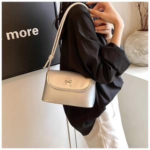 Detail of silver faux leather shoulder bag with metallic bow and knotted strap design