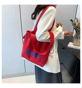 Detailed view of red canvas tote bag with Beach print and wide shoulder strap