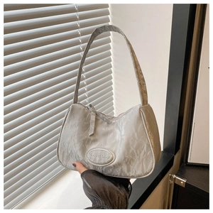 Close-up of silver-grey marble textured underarm bag with circular metallic logo detail