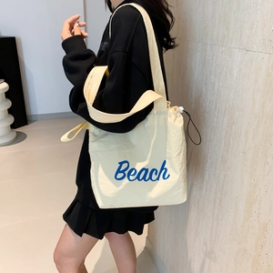 Off-white canvas tote bag with blue Beach print and drawstring closure for women