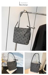 Close-up of vintage grey polka dot tote with a decorative black silk side bow