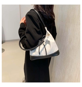 Contrast bow canvas tote bag with black leather base shown on model shoulder for daily wear