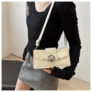 Creamy white crossbody bag with silver planet ring buckle shown on female model